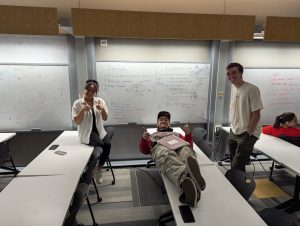 Build Team members showing off their design ideas on a white board